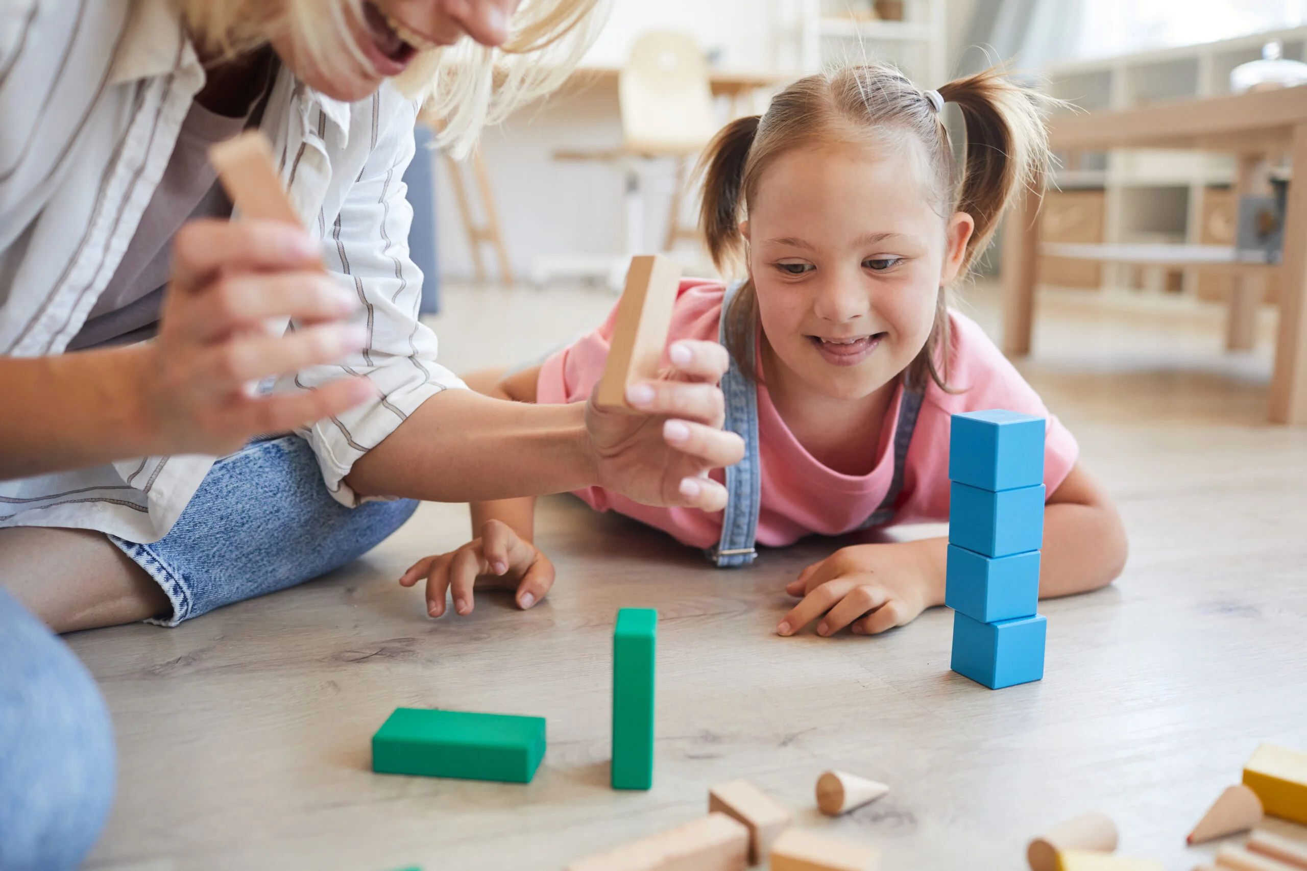 Girl playing with blocks with mother aba or applied behavior analysis is